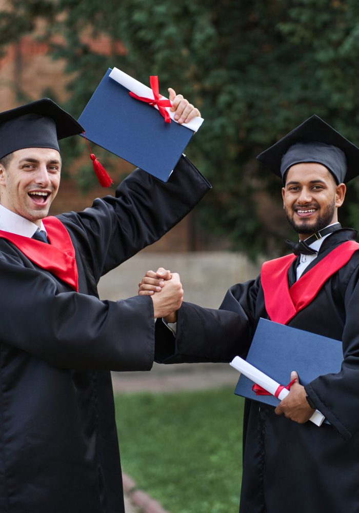 two-international-graduate-celebrating-graduation-university-campus-looking-camera-scaled-qj2x8dyapnp5b3mk6usan9hcpbkeu5gzm2xu3kt1qo